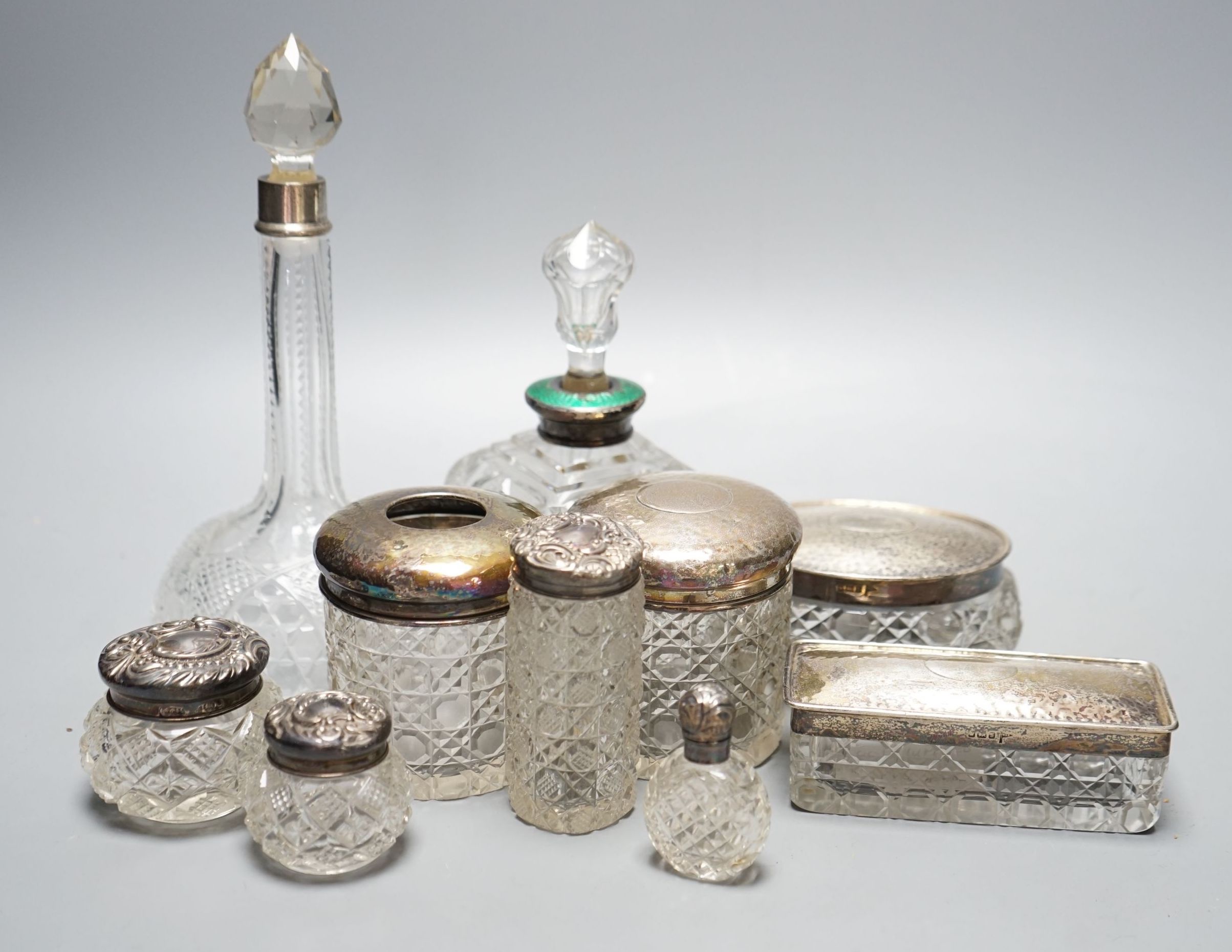 Two silver mounted cut glass scent bottles, including enamel(a.f.) and eight various dressing table items with silver lids.